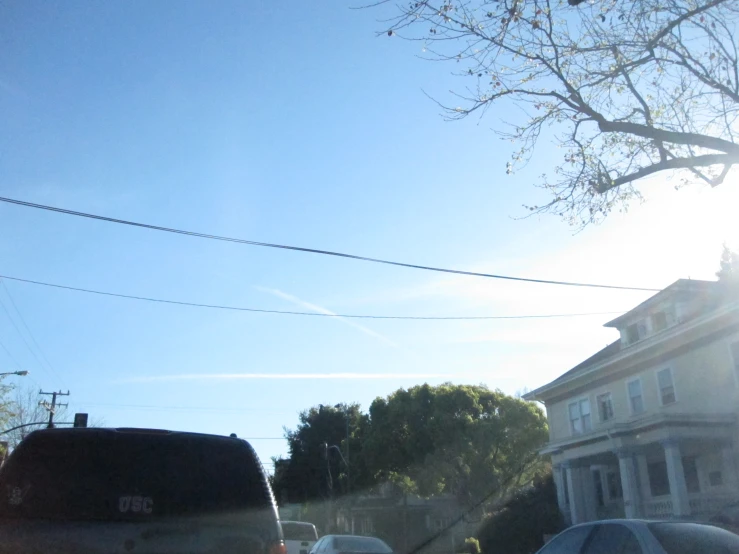 an image of a car passing by a tree and house