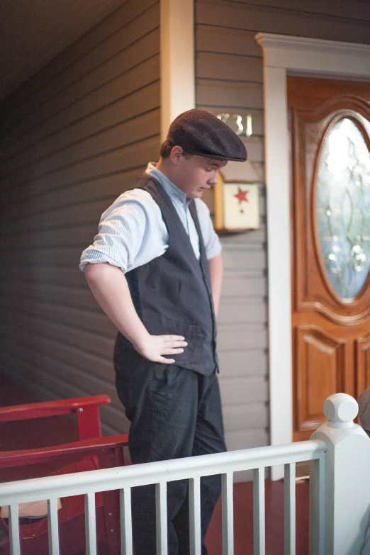 man in suspenders standing outside a porch door