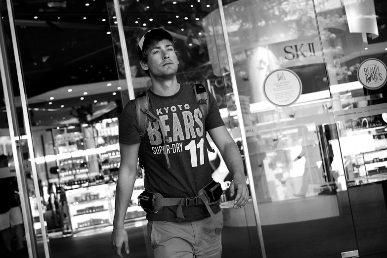 man walking past the glass doors of a store