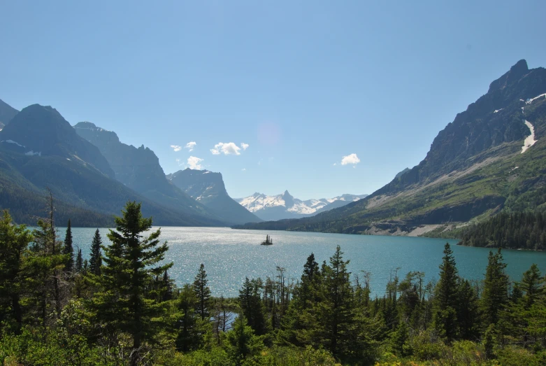 boat in large lake near mountain on sunny day