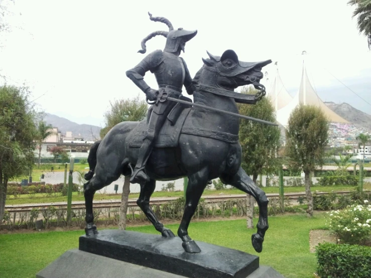 a statue of a rider on horseback in the center of a park