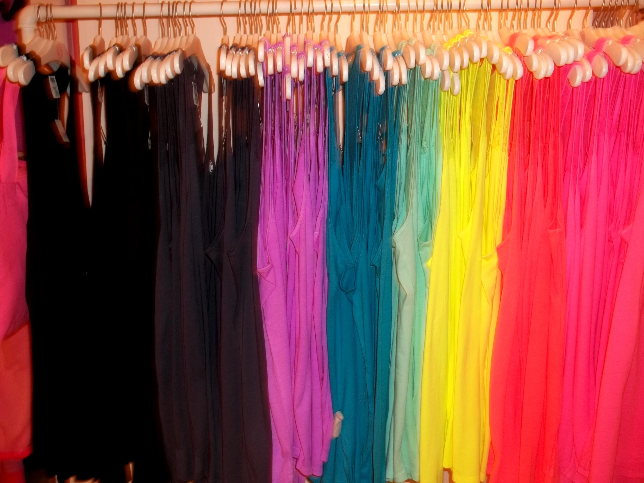 a rainbow of colored material hangs in front of another rainbow colored object