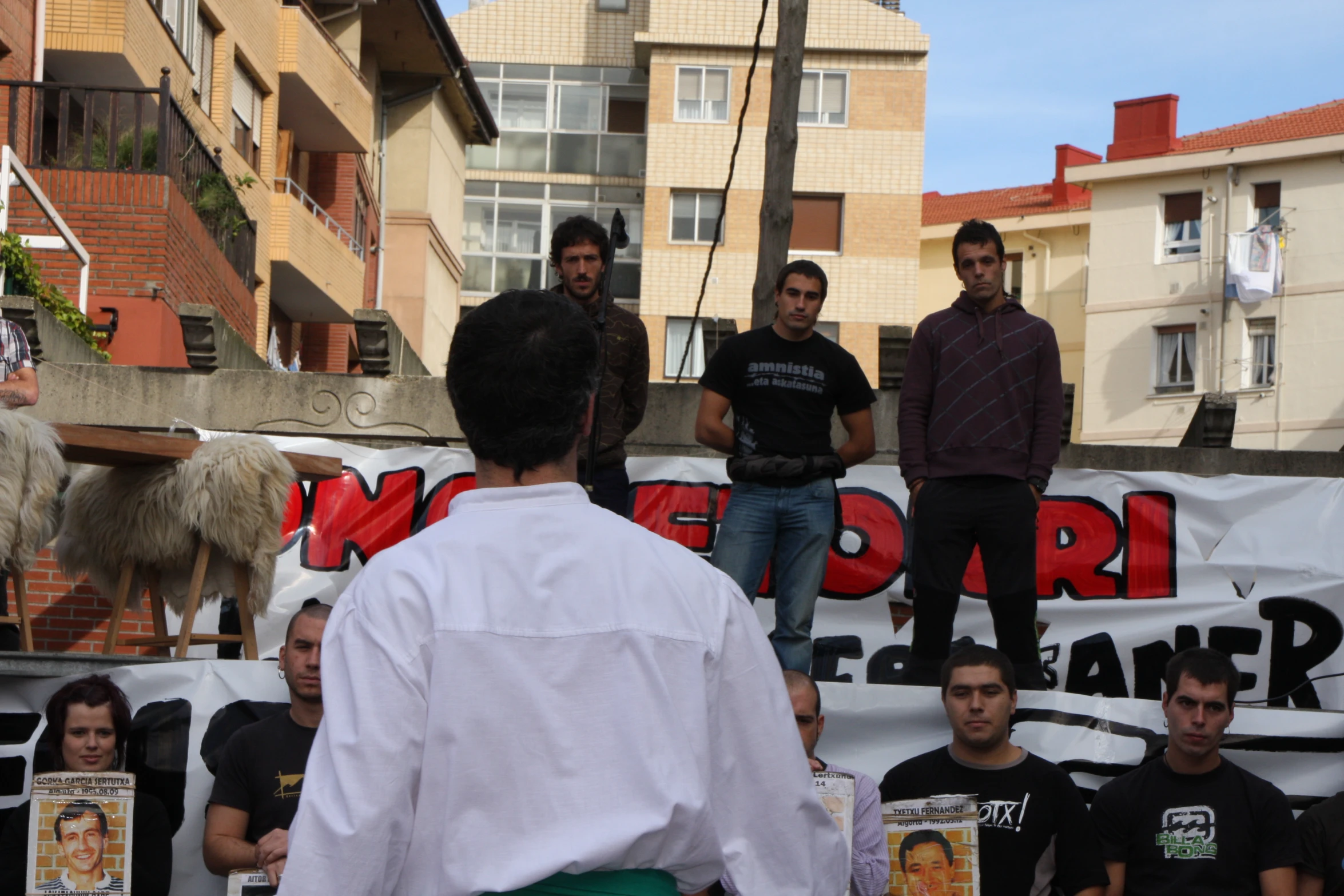 people in town at outdoor event with two men speaking