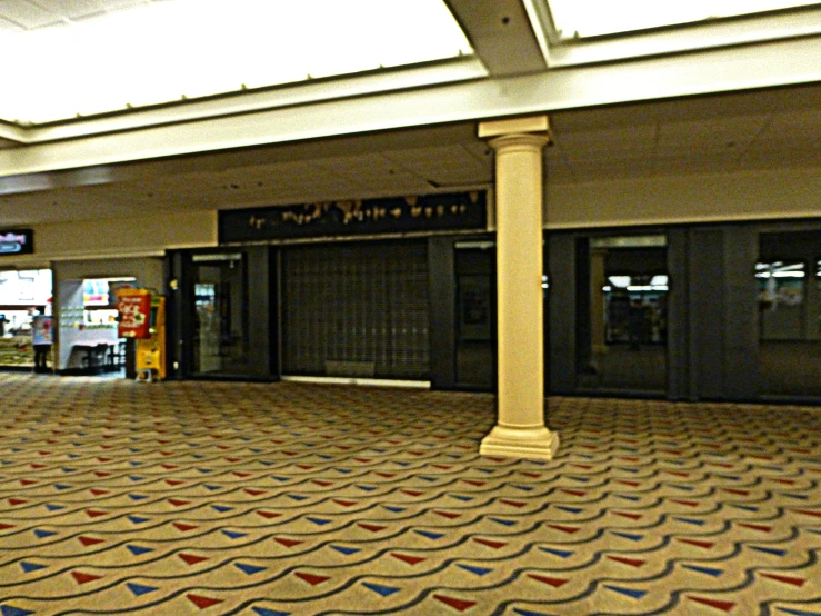 a large white pillar in a hallway with a large amount of carpet