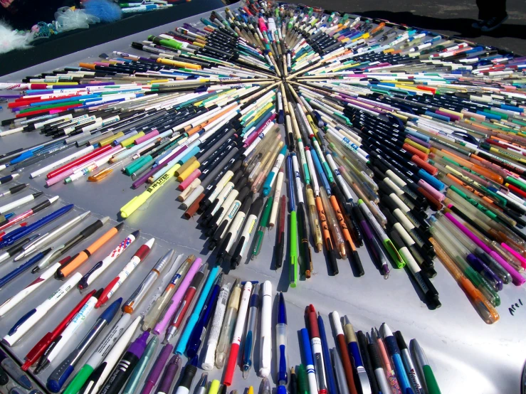 a large group of different colored crayons on a table