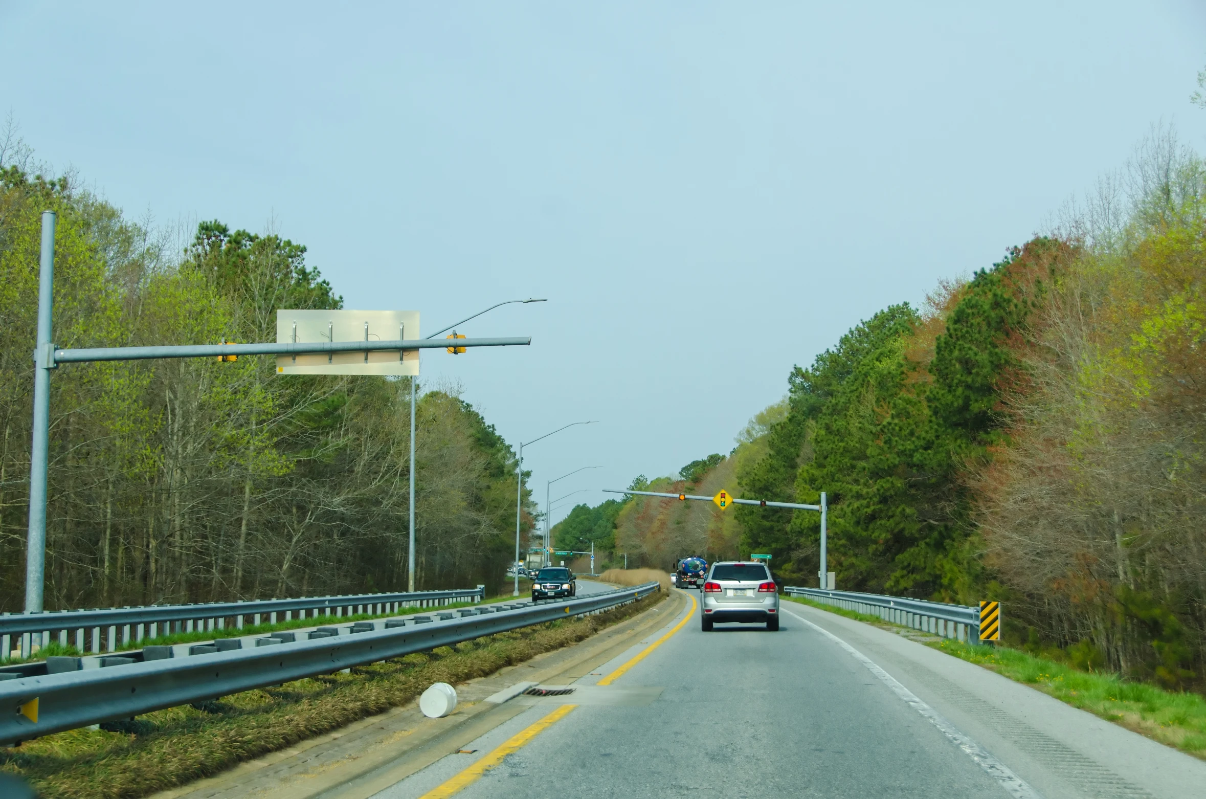 a truck driving down a road through the forest