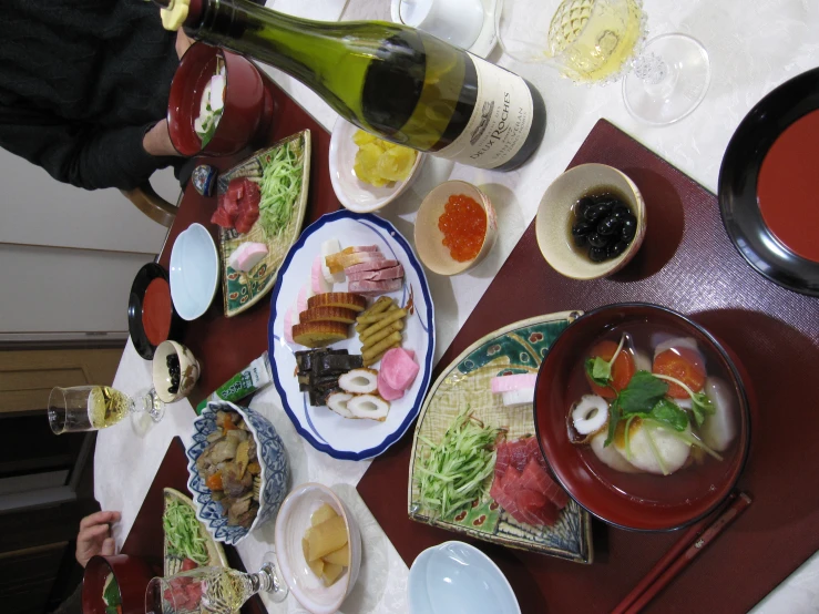 a meal set up on a dining table with wine