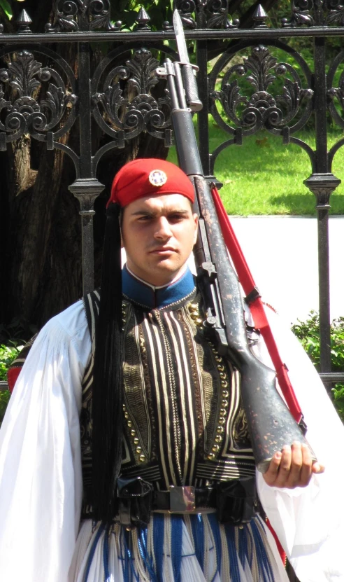 a man wearing uniform holding a rifle