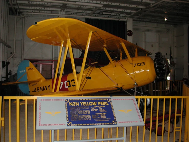 the model yellow plane is on display in a museum