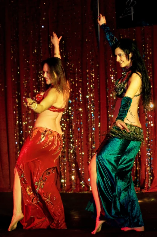 two women dressed in belly suits on stage