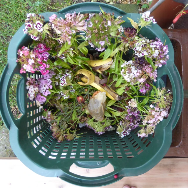 there is purple flowers in the basket on the table