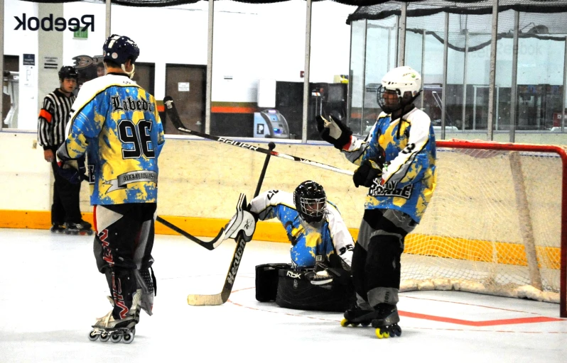 hockey players in their uniforms play near goal