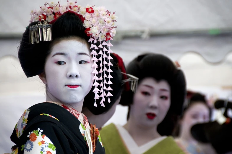 three geisha are posing at the fair