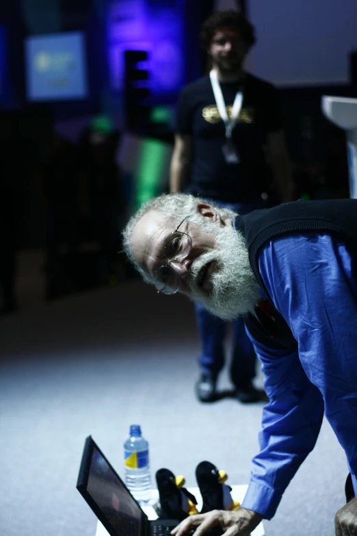 man looking at laptop with water bottle in the background