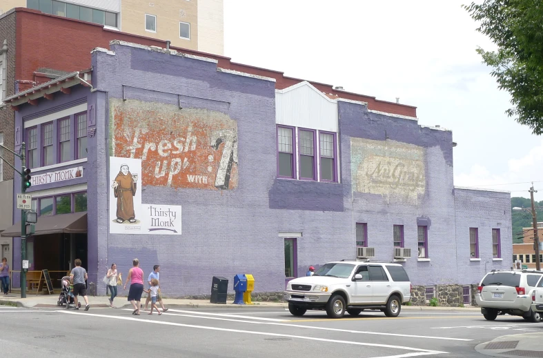 a group of people walking outside of a purple building