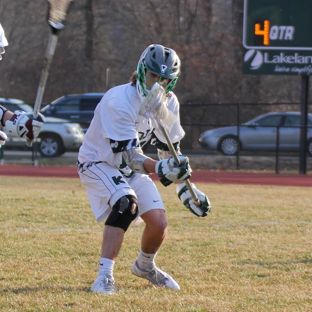 a couple of men playing a game of lacrosse