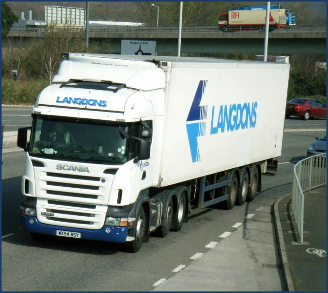 a big truck driving down the road near a barrier