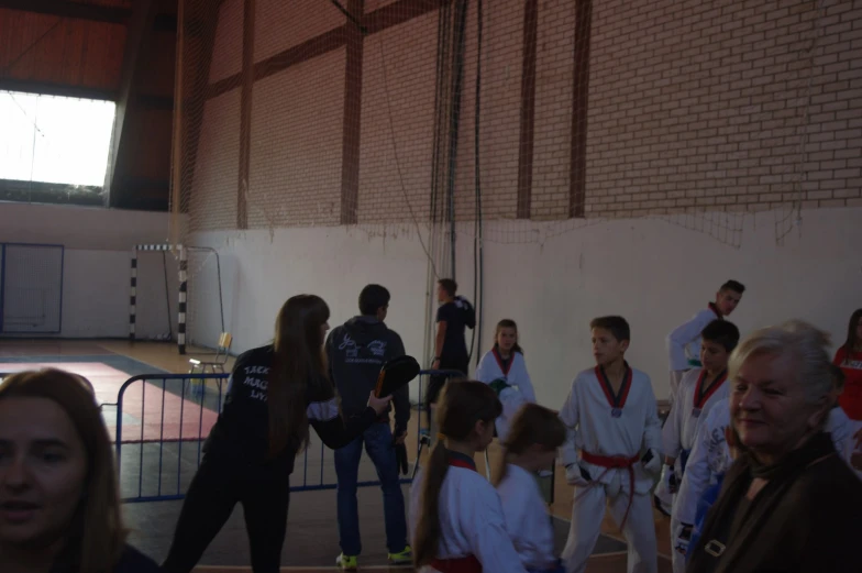 an old man getting ready for a karate match with a crowd in the background