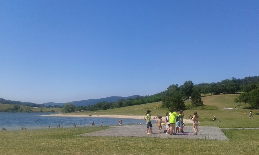 people are standing on a path by the water