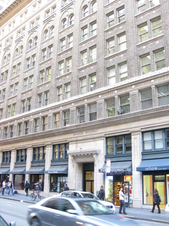 a car in front of a building that has shops and other buildings