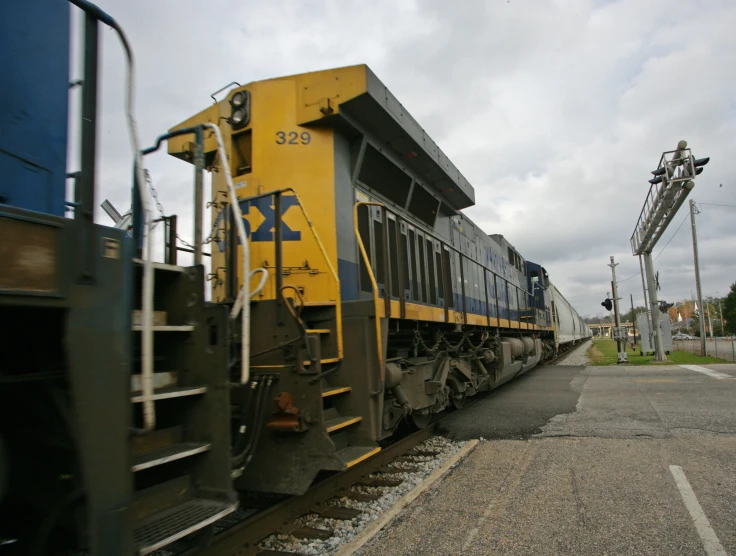 a yellow and blue train moving down the tracks