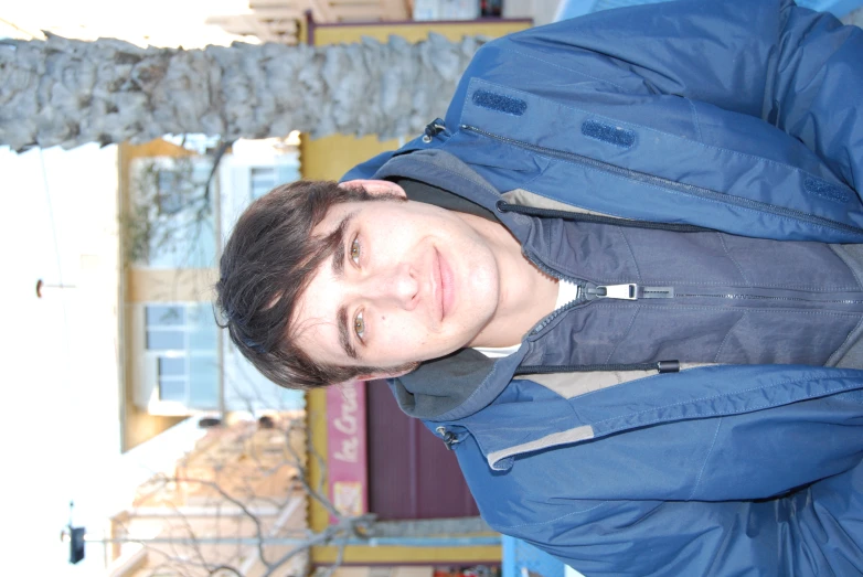 a man wearing a blue jacket posing for the camera