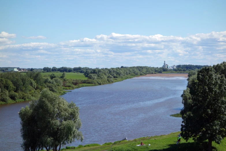 a lake in a countryside with trees and a few benches