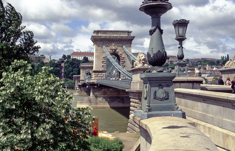 view from underneath a bridge with buildings and light poles in the background