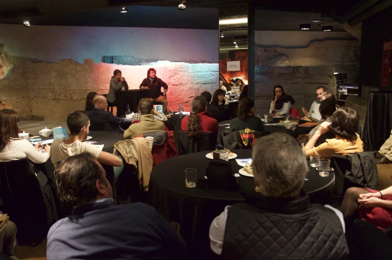 a group of people are having a conversation at a social gathering