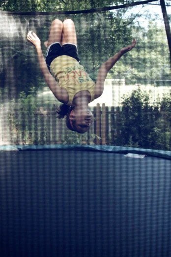 a woman hanging off the side of a trampoline