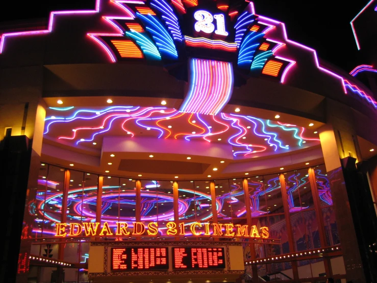 brightly lit sign above entrance in large mall area