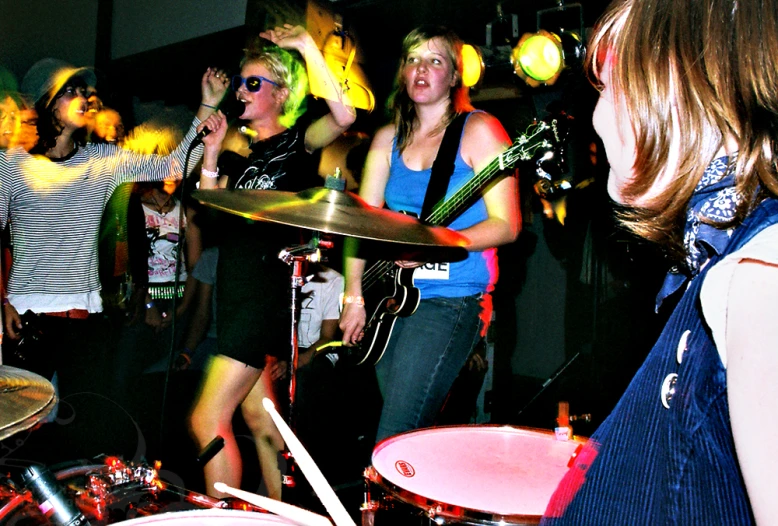 a group of young people standing around each other playing instruments