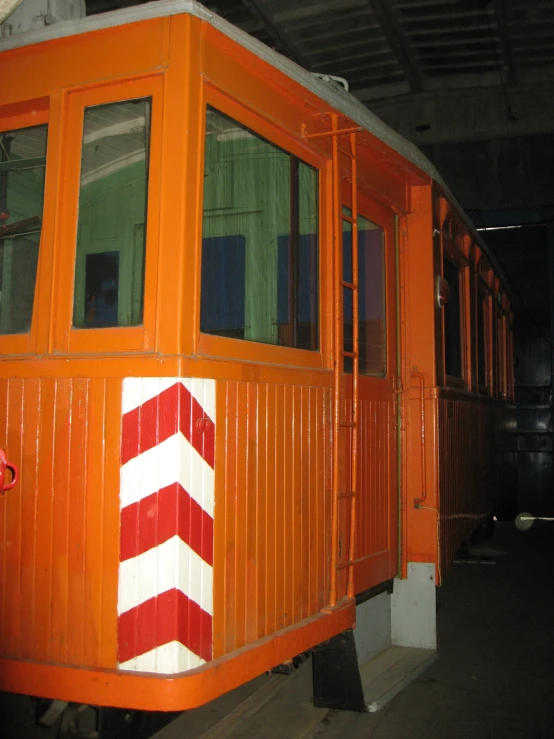 an orange train car sitting in the station