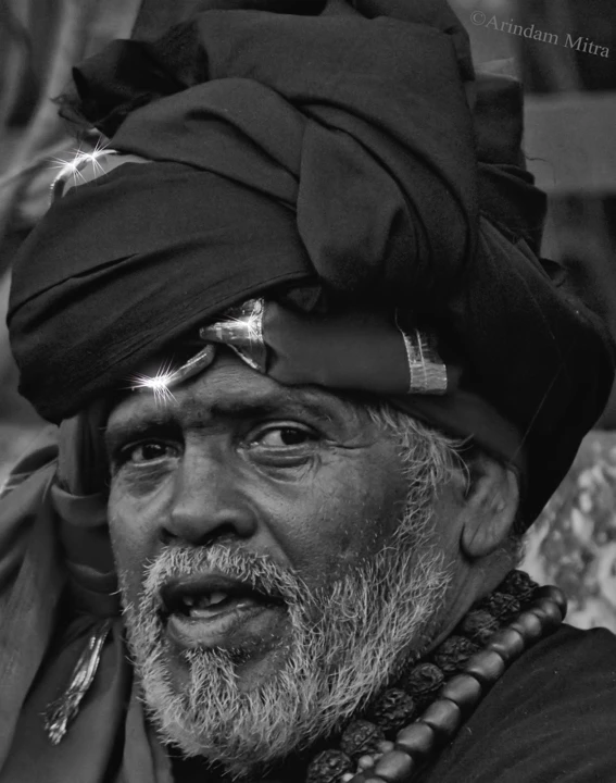 a man with long grey hair and beard wearing a turban