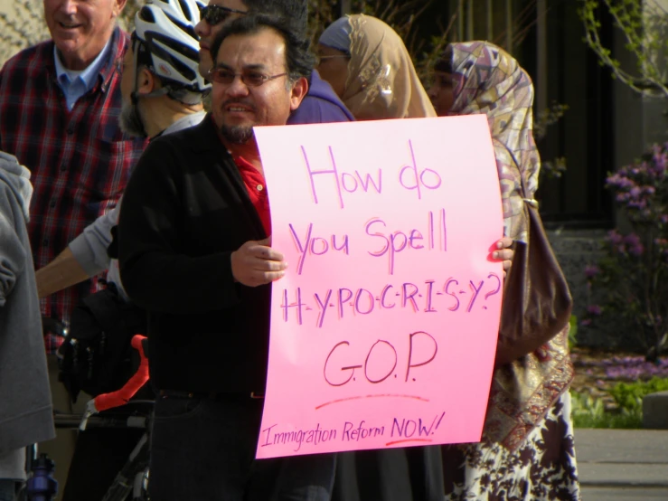 a protester is holding up a pink sign