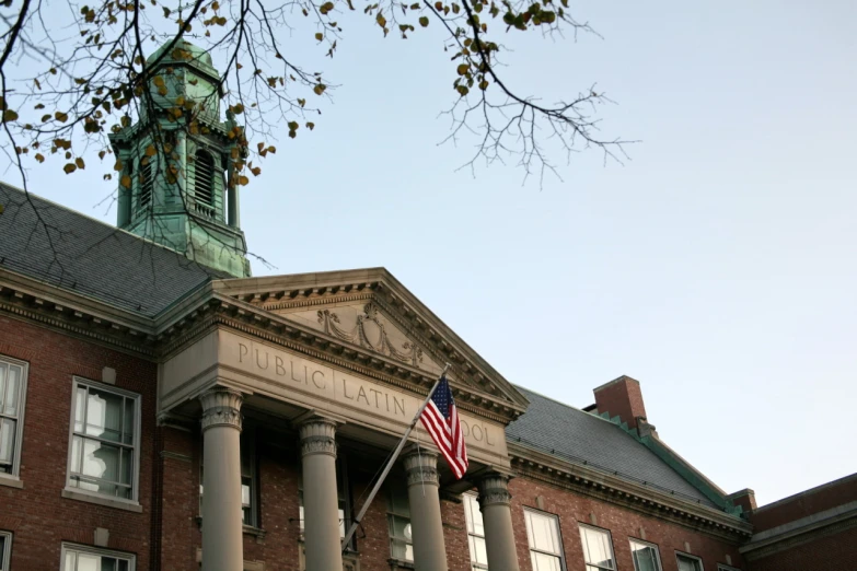 a flag on top of a building with pillars and a clock