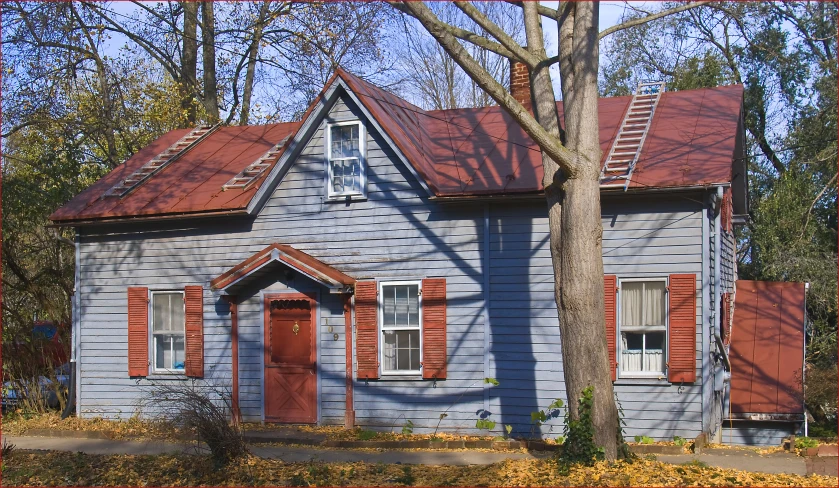 a small blue house with shutters and a brown roof