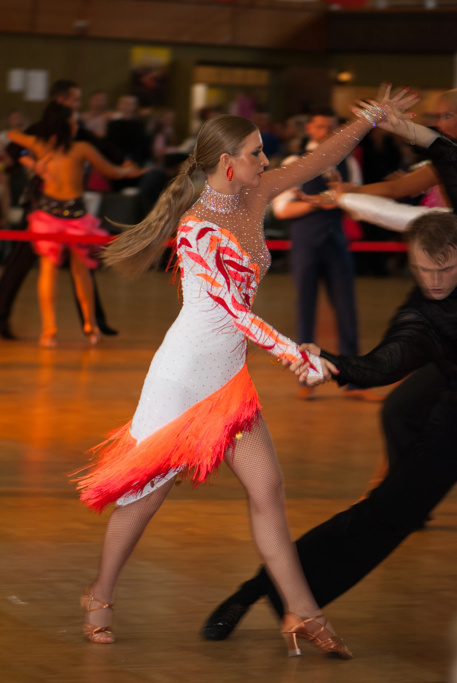 people are gathered in a dance class, some of them are wearing feather skirts