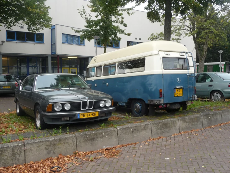 two cars and an rv parked near each other in front of a building