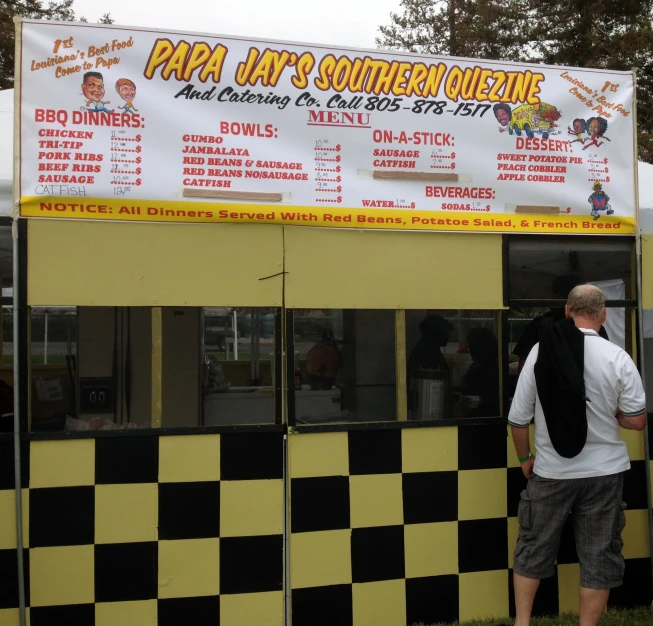 a man stands outside a large sandwich stand