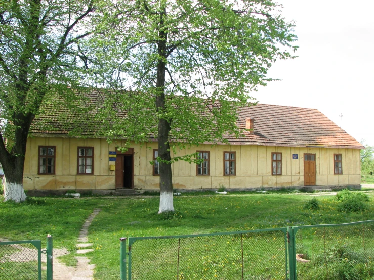 a building with a small gate and a tree in front of it