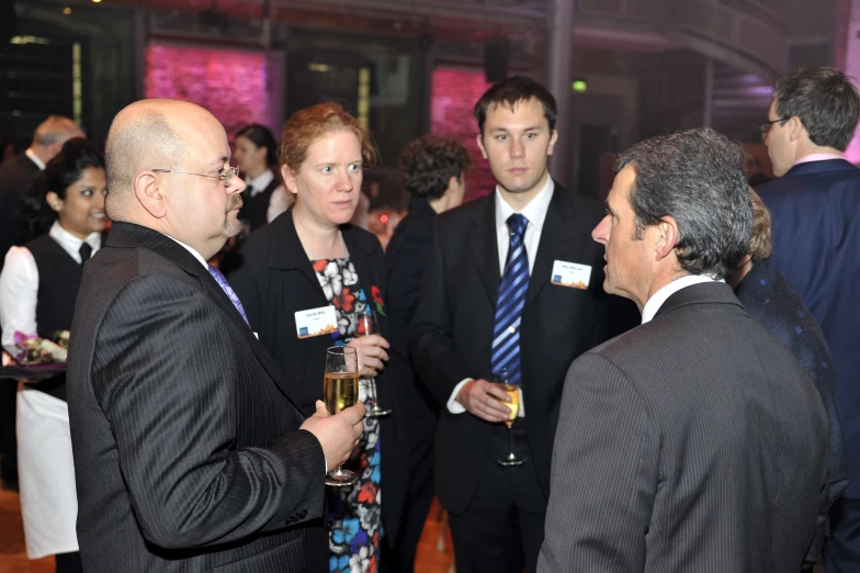 several business men talking to one another at a party