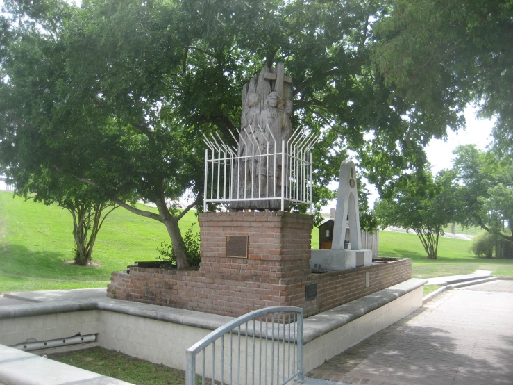 a statue of the virgin mary of god is surrounded by a fence