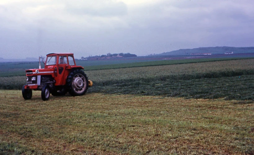 the farmer is driving his farm tractor in the field