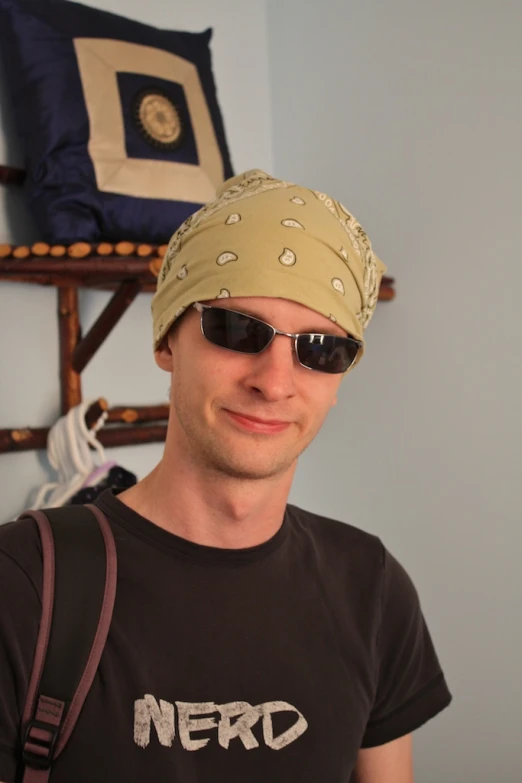 a young man with sunglasses and head scarf looking at the camera