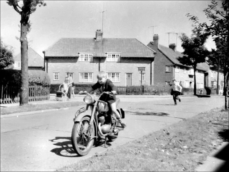 a man riding on the back of a motorcycle down a street