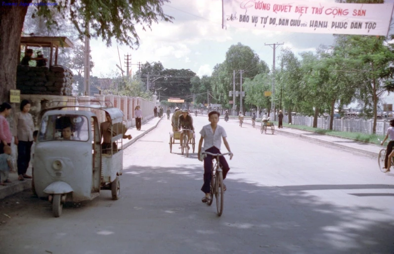 a young man riding a bike down a street