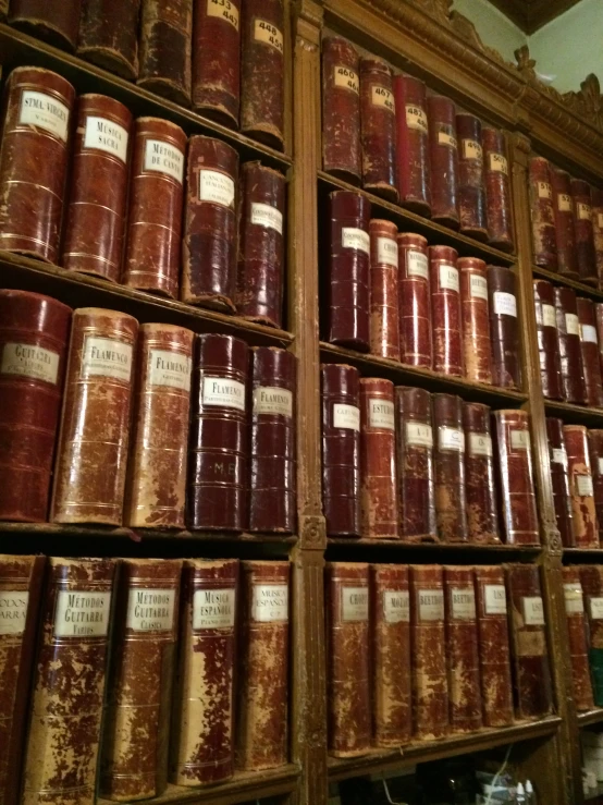 a number of books on a shelves with gold trim