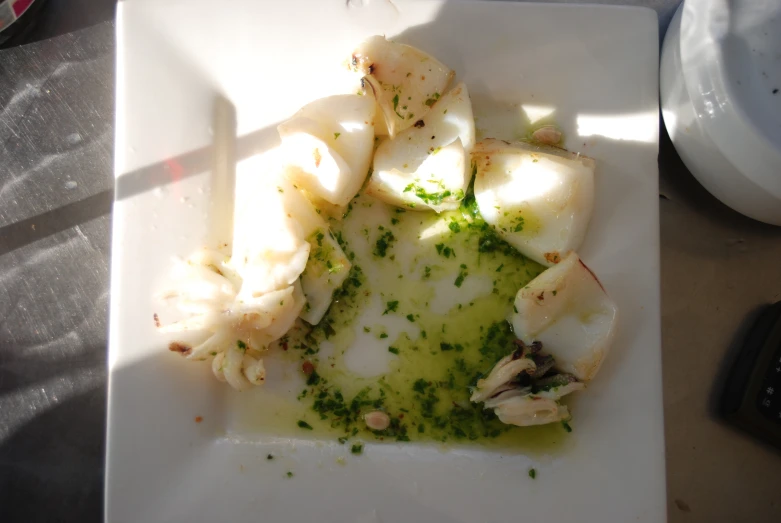 food is left on a square plate, including scallops