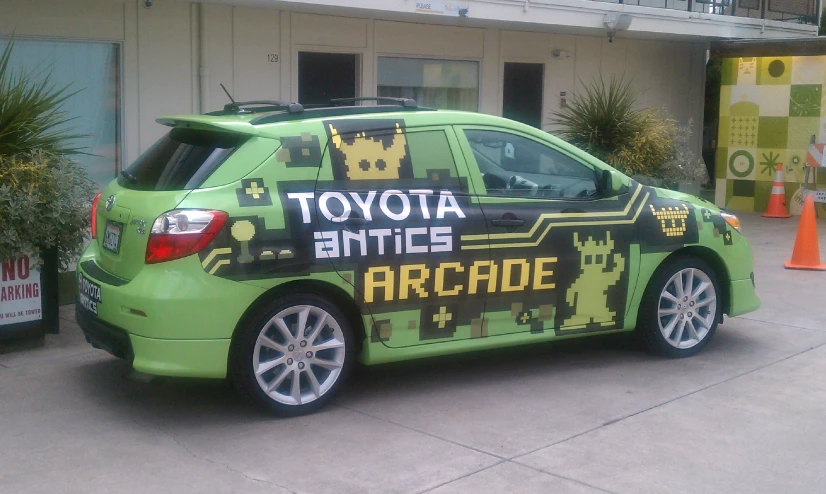 a green car is parked on the side of the road